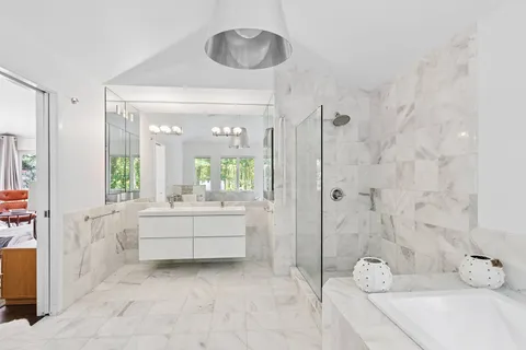 a bathroom with a tub sink and mirror