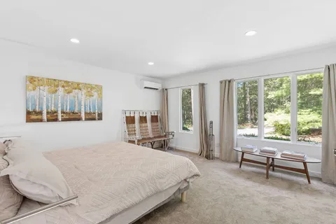 a bedroom with a bed and a large window