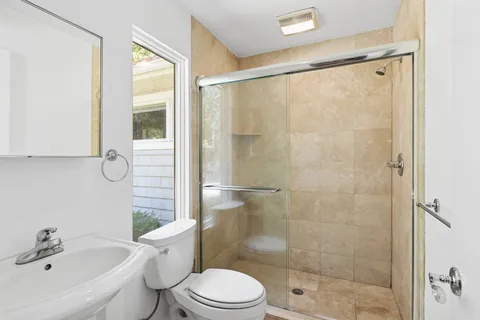 a bathroom with a shower a toilet and a sink