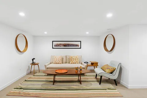 a living room with furniture and a mirror