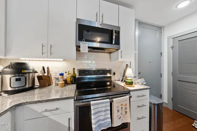 a kitchen with granite countertop a sink and a stove top oven