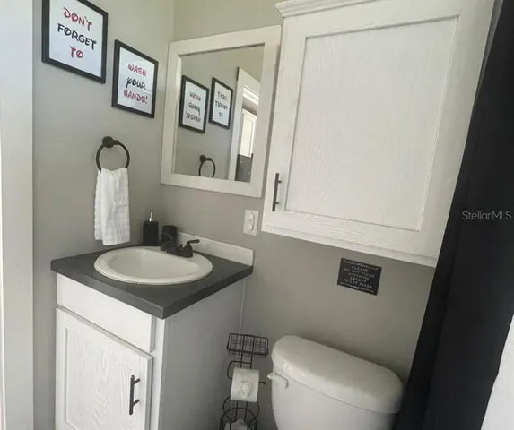 a bathroom with a toilet a sink and mirror