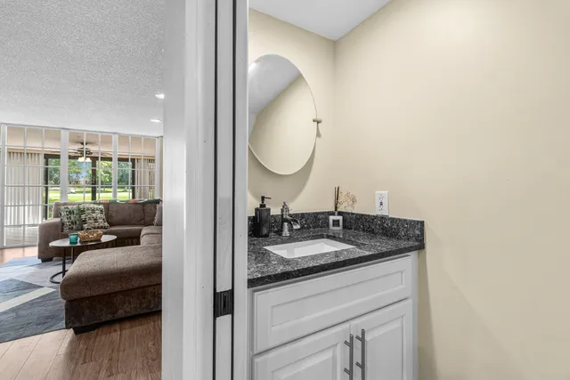 a en suite bathroom with a granite countertop sink and a mirror