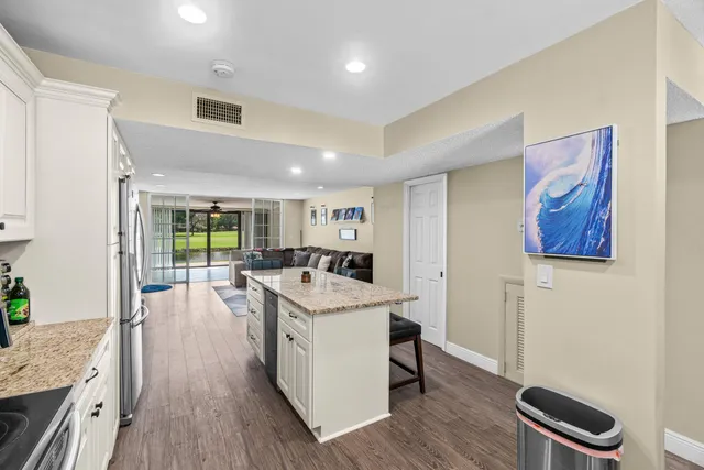 a kitchen with a stove a sink a refrigerator and wooden floor