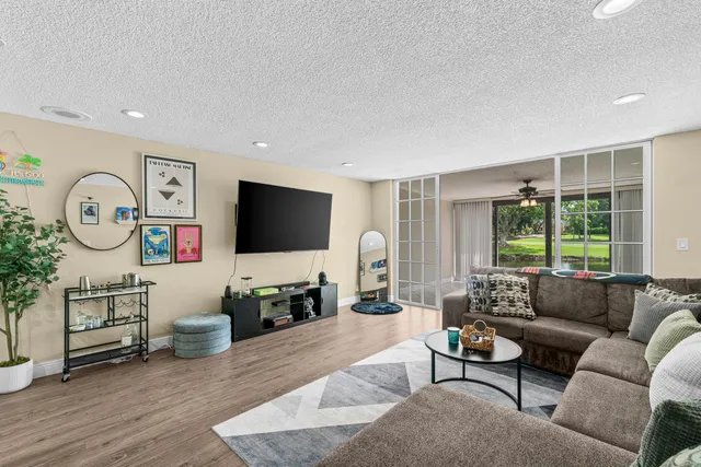 a living room with furniture a window and a flat screen tv