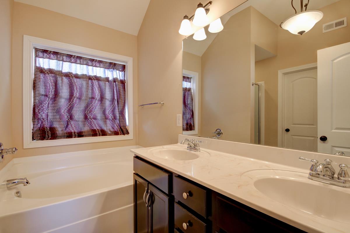 3725 Suiter Road Clarksville, TN 37040 - Photo 8 of 15 a bathroom with a sink a large mirror and a bathtub with shower