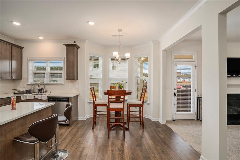 13709 Whitman Lane Covington, GA 30014 - Photo 14 of 36 a kitchen with stainless steel appliances a dining table chairs stove refrigerator and cabinets