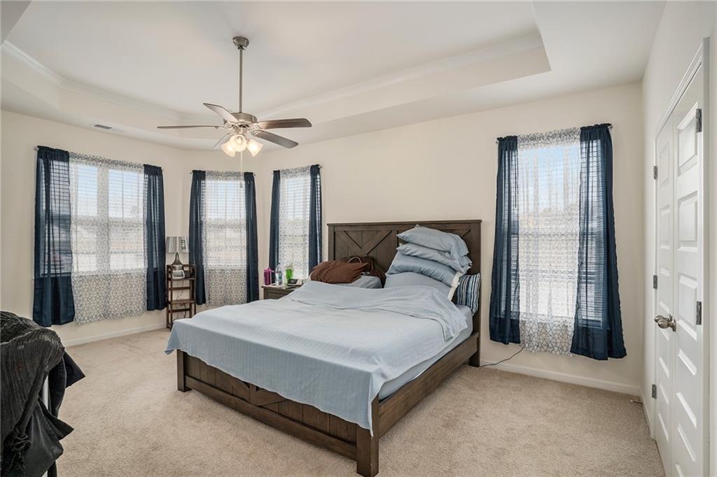 13709 Whitman Lane Covington, GA 30014 - Photo 15 of 36 a spacious bedroom with a bed and a chandelier