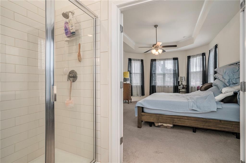 13709 Whitman Lane Covington, GA 30014 - Photo 21 of 36 a spacious bedroom with a bed and a chandelier