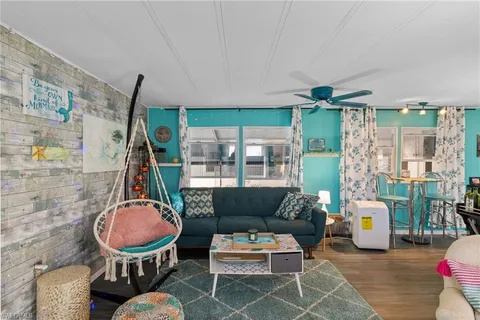 a living room with furniture a rug and a floor to ceiling window