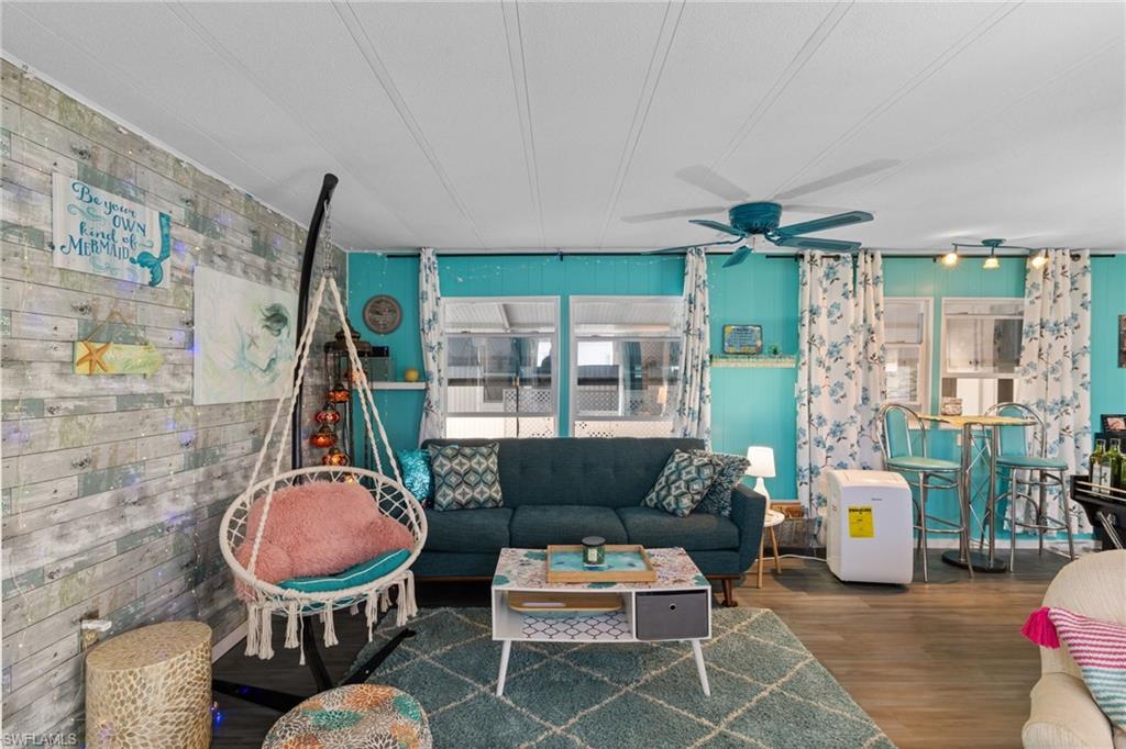 43 Enchanting Boulevard, Unit E43 Naples, FL 34112 - Photo 14 of 36 a living room with furniture a rug and a floor to ceiling window