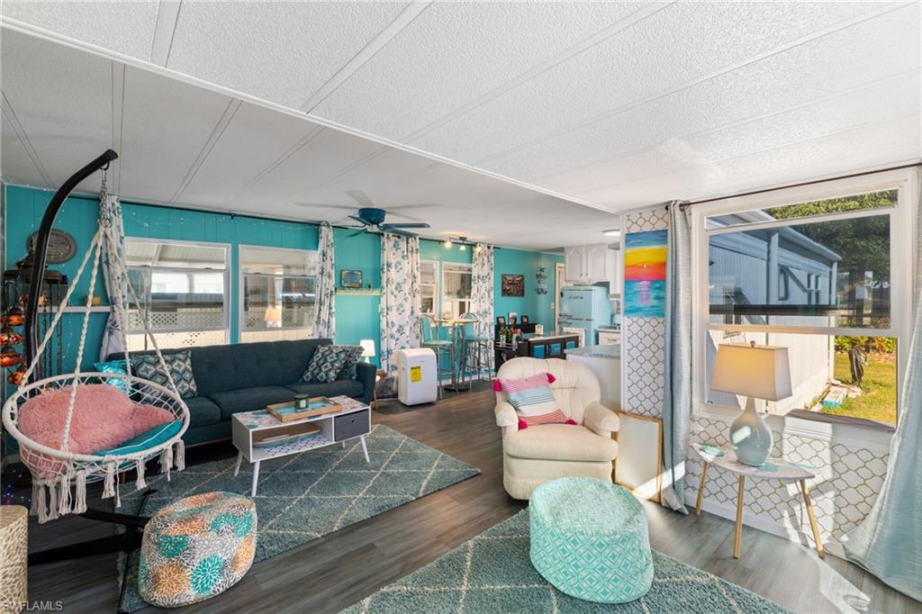 43 Enchanting Boulevard, Unit E43 Naples, FL 34112 - Photo 15 of 36 a living room with furniture and a floor to ceiling window
