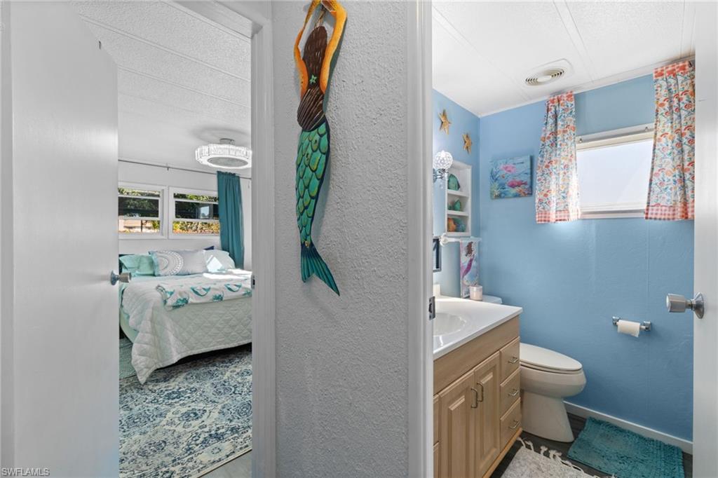 43 Enchanting Boulevard, Unit E43 Naples, FL 34112 - Photo 21 of 36 a bathroom with a toilet a sink and mirror