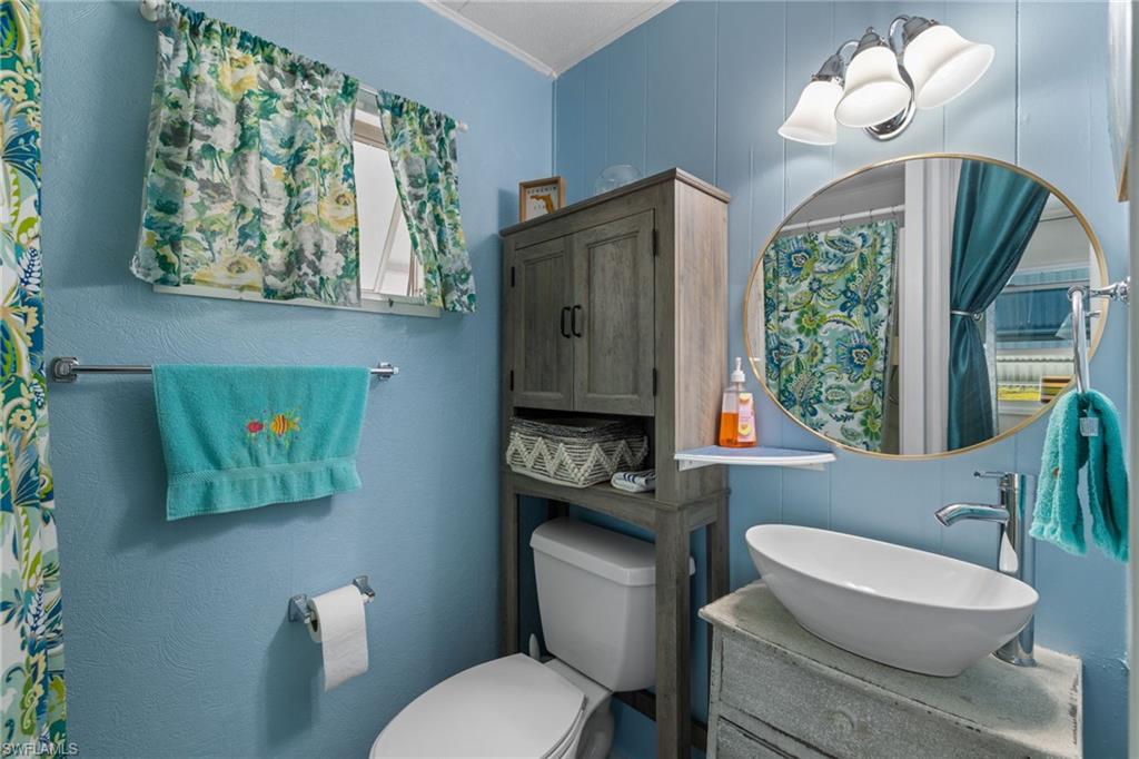 43 Enchanting Boulevard, Unit E43 Naples, FL 34112 - Photo 23 of 36 a bathroom with a toilet a sink and a mirror