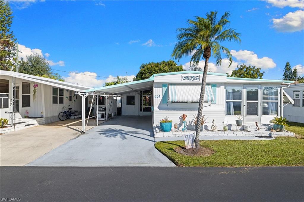 43 Enchanting Boulevard, Unit E43 Naples, FL 34112 - Photo 28 of 36 a front view of a house with garden and patio