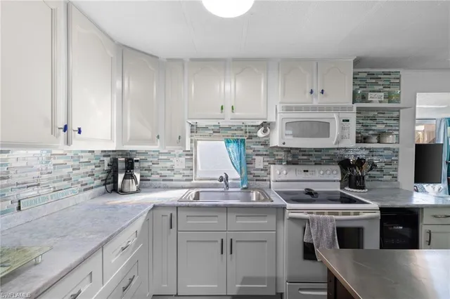 a kitchen with kitchen island granite countertop a sink stainless steel appliances and white cabinets