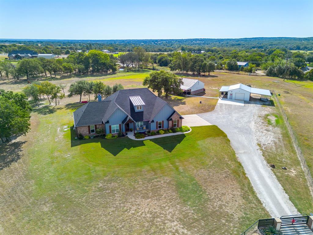 an aerial view of a house with pool and a yard