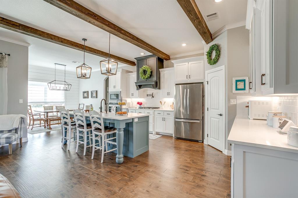 229 Oak Tree Drive Poolville, TX 76487 - Photo 12 of 40 a kitchen with stainless steel appliances a dining table chairs stove and refrigerator