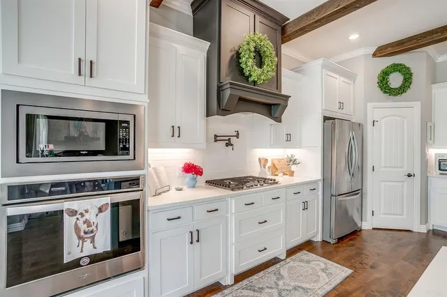 a kitchen with stainless steel appliances a stove a refrigerator and cabinets