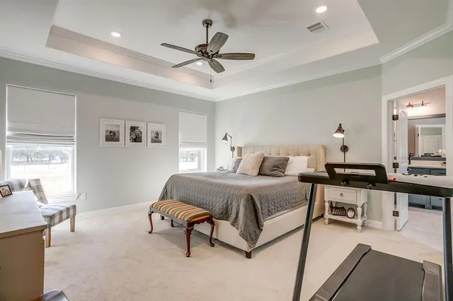 a spacious bedroom with a bed a chandelier and window
