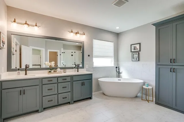 a spacious bathroom with a double vanity sink mirror and bathtub