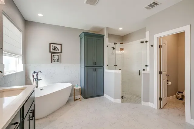 a bathroom with a tub a shower and a sink