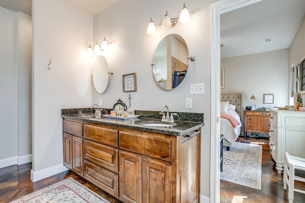 229 Oak Tree Drive Poolville, TX 76487 - Photo 33 of 40 a en suite bathroom with a granite countertop sink and a mirror