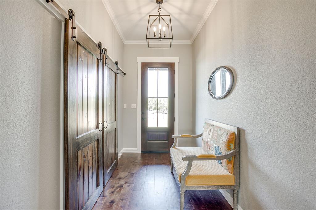 229 Oak Tree Drive Poolville, TX 76487 - Photo 9 of 40 a view of a hallway with wooden floor and windows