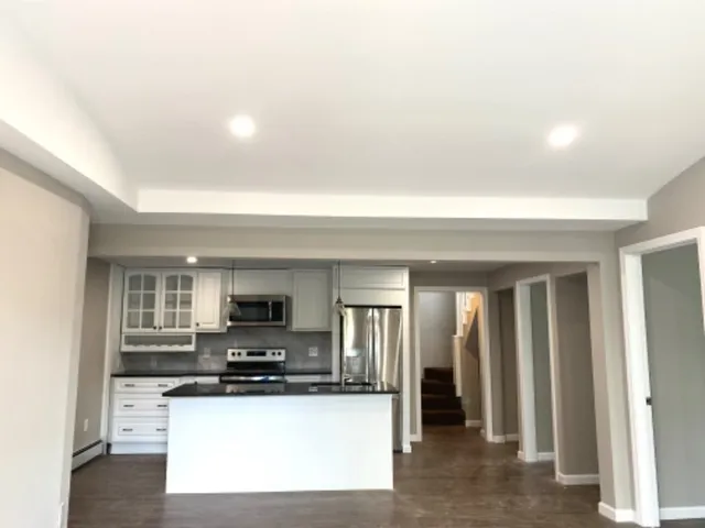 a view of kitchen with sink and refrigerator