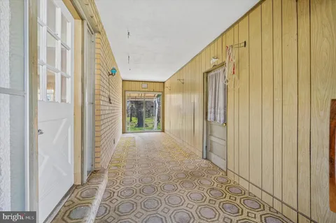 a view of a hallway with wooden walls and windows