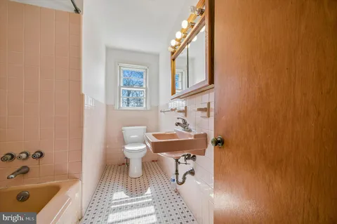 a bathroom with a sink a bathtub and a window