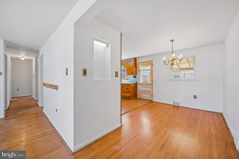 a view of a livingroom with wooden floor and kitchen space