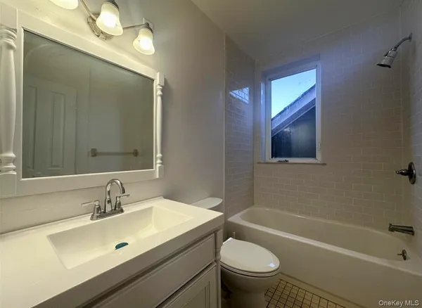 a bathroom with a sink mirror vanity and toilet