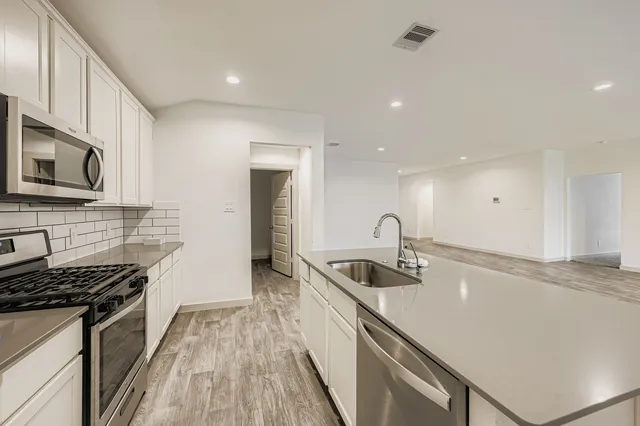 a kitchen with stainless steel appliances granite countertop a sink stove and refrigerator