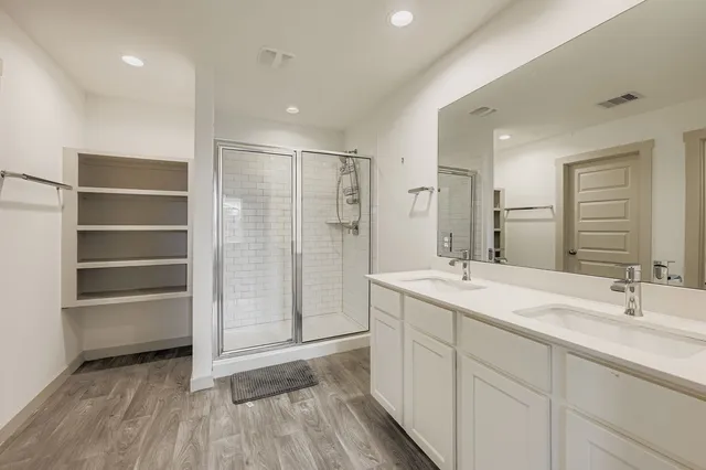 a spacious bathroom with a shower sink and mirror