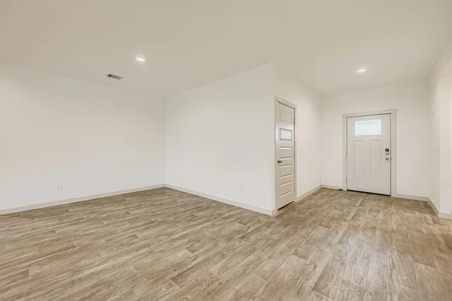a view of an empty room with wooden floor