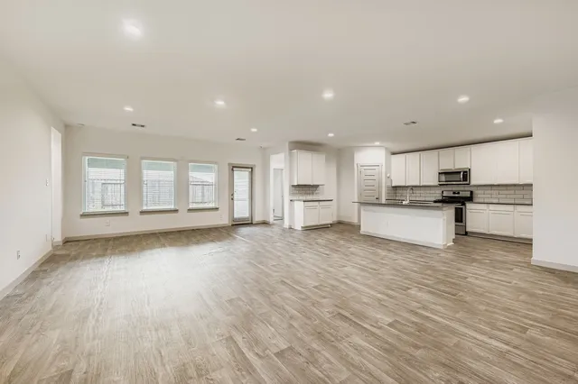 a view of kitchen with wooden floor and electronic appliances