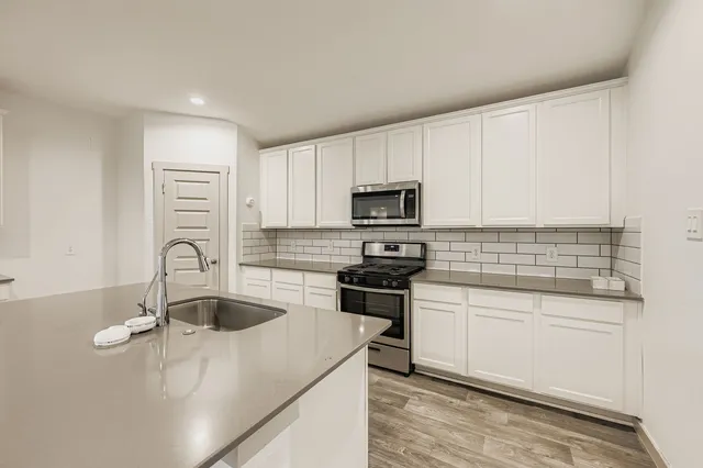 a kitchen with appliances a sink and cabinets
