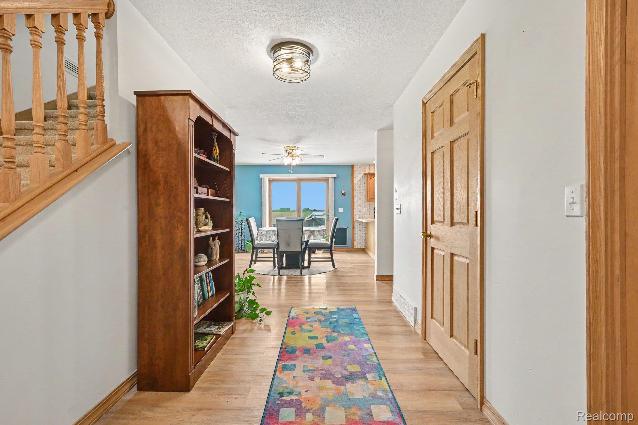 996 Arbogast Road Union City, MI 49094 - Photo 8 of 34 Entryway featuring wood-finish flooring, a wood staircase with balusters, a built-in wood bookshelf, and a flush-mount ceiling light fixture