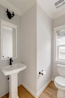 a bathroom with a sink a toilet and a window