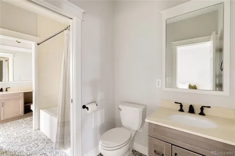 a bathroom with a sink a toilet and a mirror