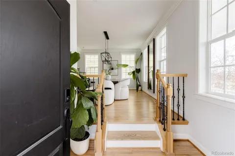 a dining room with furniture a potted plant and wooden floor
