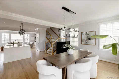 a dining room with furniture a chandelier and wooden floor
