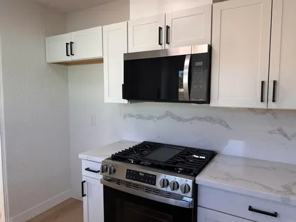 a stove top oven sitting inside of a kitchen