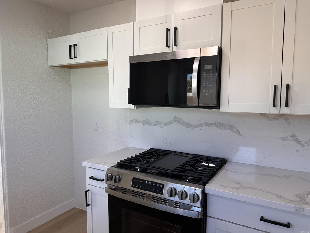 5412 Cervantes Avenue San Diego, CA 92114 - Photo 12 of 28 a stove top oven sitting inside of a kitchen