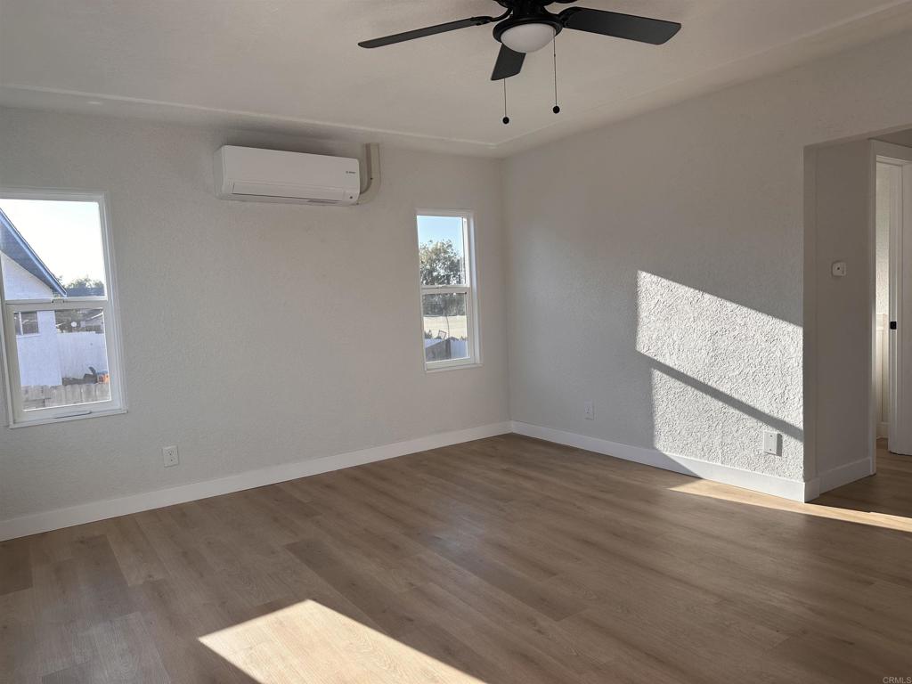 5412 Cervantes Avenue San Diego, CA 92114 - Photo 15 of 28 an empty room with wooden floor ceiling fan and windows