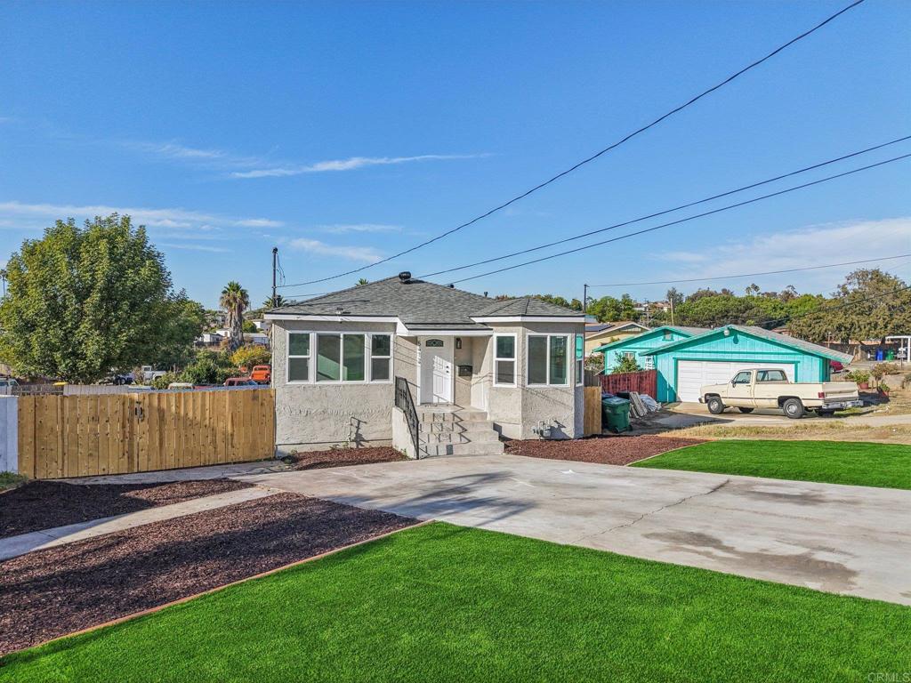 5412 Cervantes Avenue San Diego, CA 92114 - Photo 27 of 28 a front view of a house with a garden and yard