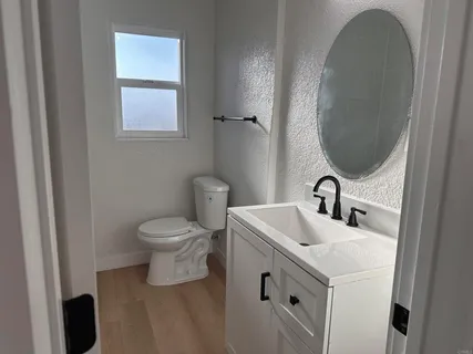 a bathroom with a toilet sink and mirror