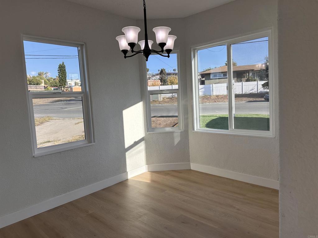 5412 Cervantes Avenue San Diego, CA 92114 - Photo 9 of 28 a view of a room with wooden floor a chandelier and windows