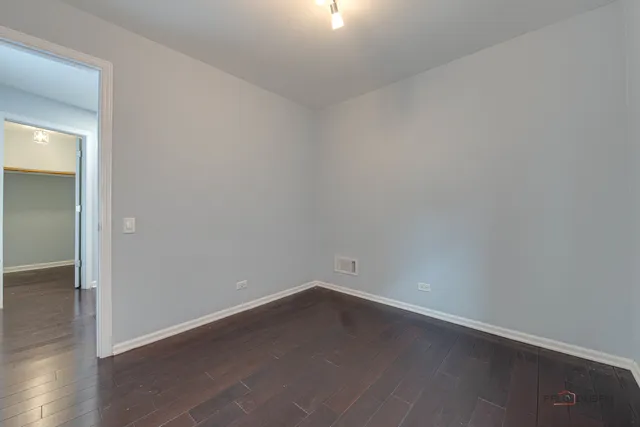 an empty room with wooden floor and white walls